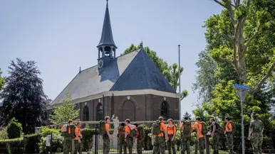 Studenten staan bij het monument te kijken