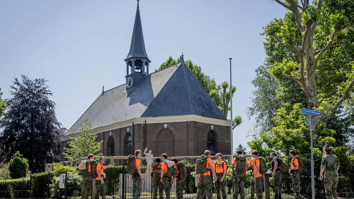 VeVa-studenten marcheren langs een kerk.