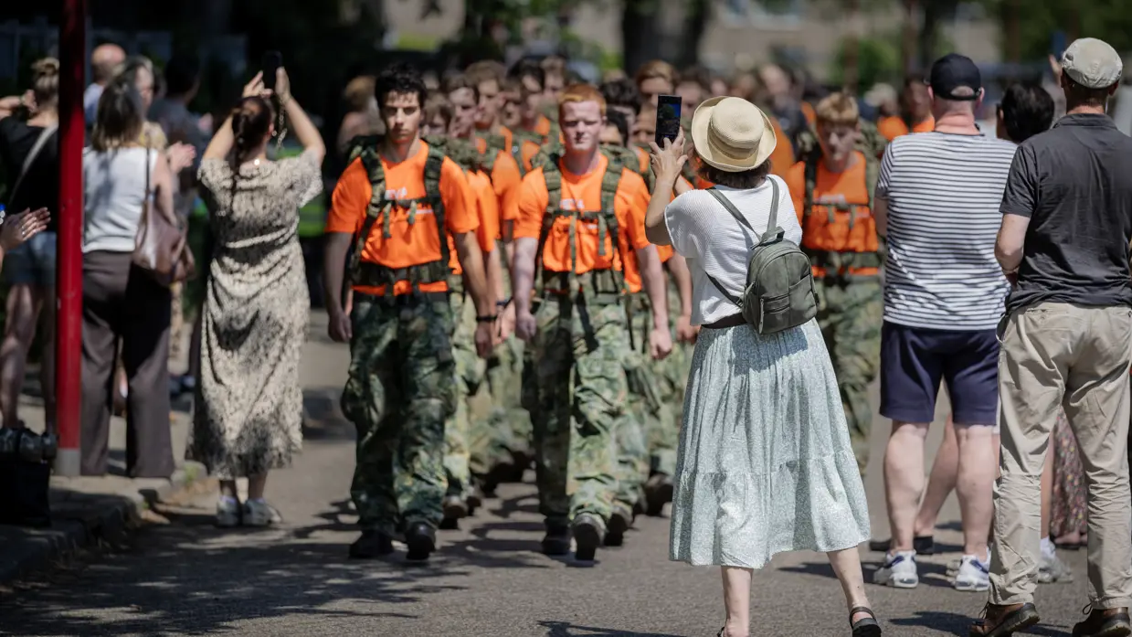 VeVa-studenten marcheren, omringd door een publiek.