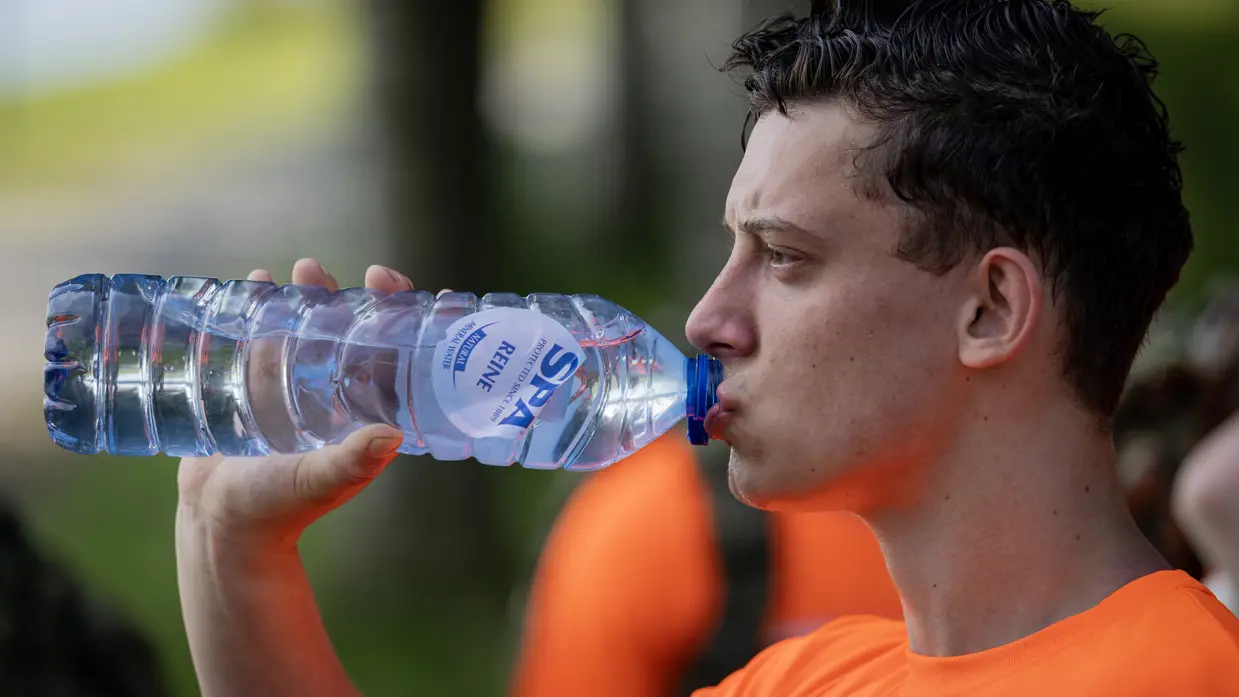 Een VeVa-student drinkt uit een waterfles.