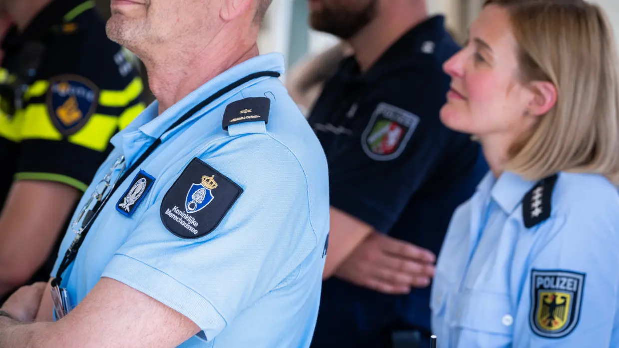Schouders met badges van de Koninklijke Marechaussee, Nationale Politie, Bundespolizei en Landespolizei Nordrhein-Westfalen