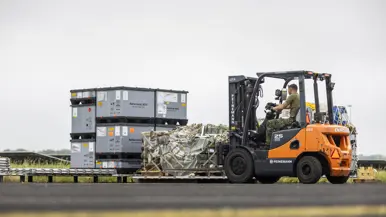 Vorkheftruck verplaatst pallet met materieel.