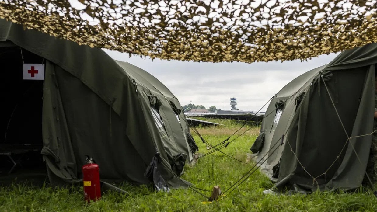  Twee groene legertenten met camouflagenetten.