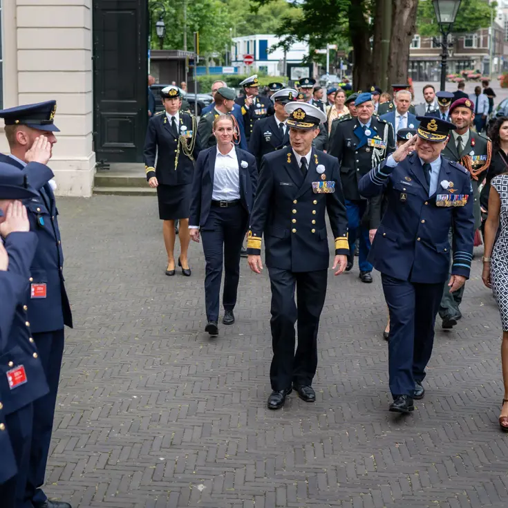 Drie luchtmachtmilitairen salueren naar de CDS en minister van Defensie als zij aankomen bij de Koninklijke Schouwburg in Den Haag 