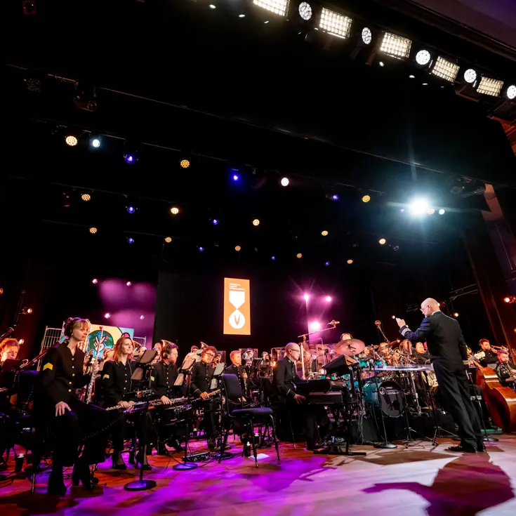 Het volledige Orkest Koninklijke Luchtmacht op het podium van de Koninklijke Schouwburg.