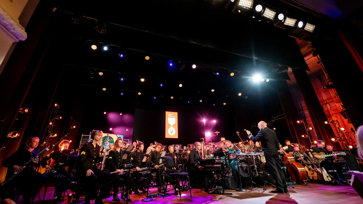 Het volledige Orkest Koninklijke Luchtmacht op het podium van de Koninklijke Schouwburg.