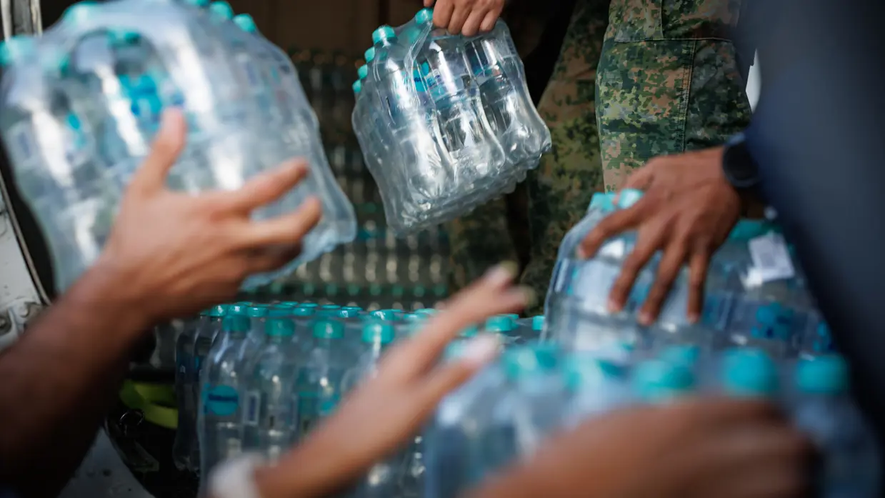 Drinkwaterflessen worden uitgeladen.