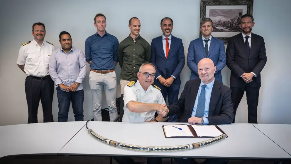 Het systeem ligt op de tafel waar de ondertekenaars achter zitten. 