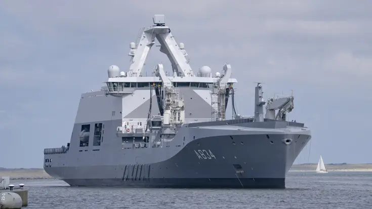 Marineschip vaart de haven binnen.