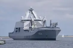 Marineschip vaart de haven binnen.