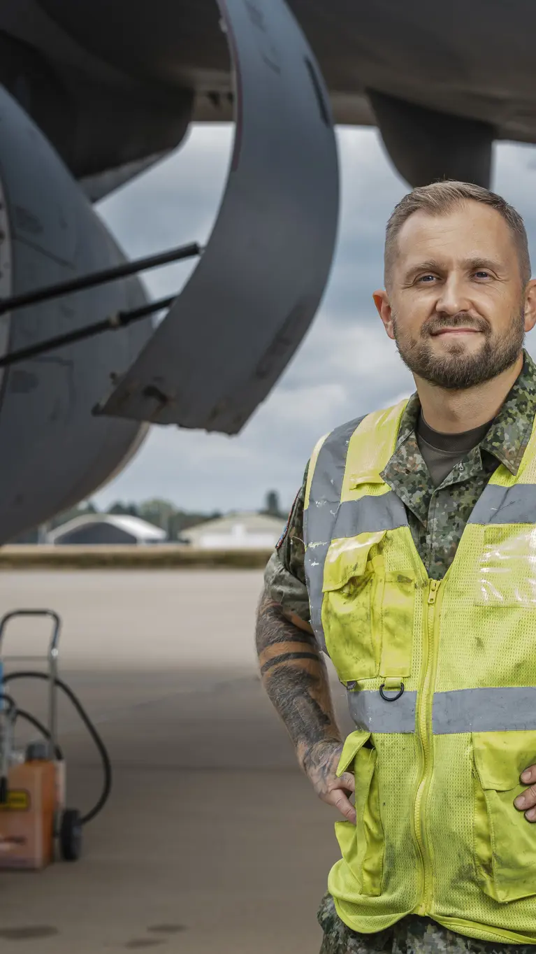 Sergeant-majoor Roy van der Mark draagt een veiligheidsvest en staat naast een A330 MRTT tijdens onderhoudswerkzaamheden. 