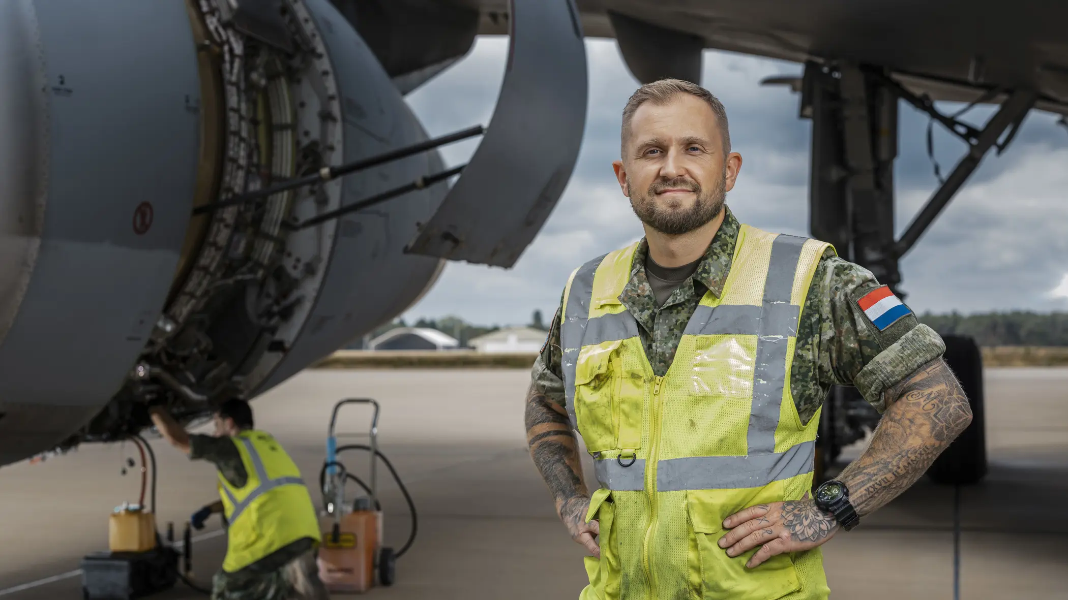 Sergeant-majoor Roy van der Mark draagt een veiligheidsvest en staat naast een A330 MRTT tijdens onderhoudswerkzaamheden. 