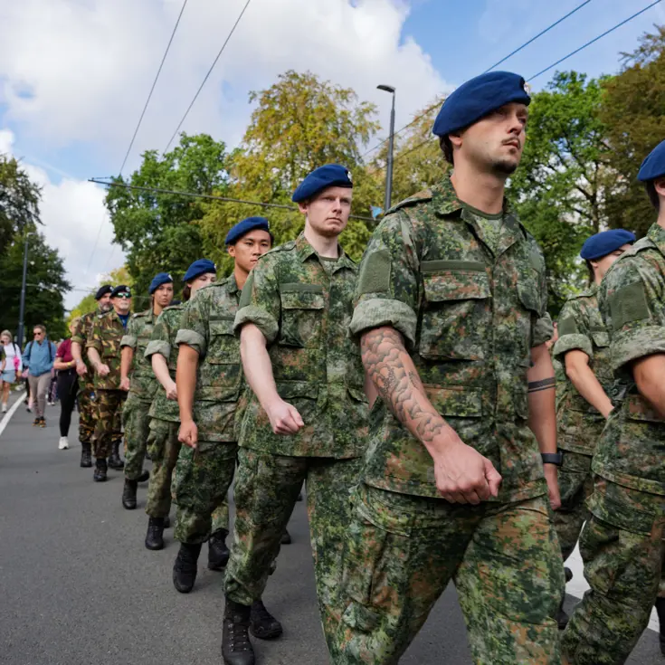Marechaussees in groene uniformen marcheren.