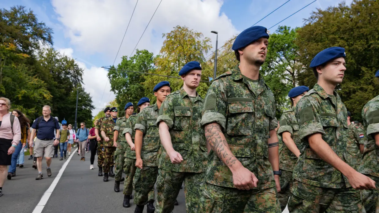 Marechaussees in groene uniformen marcheren.