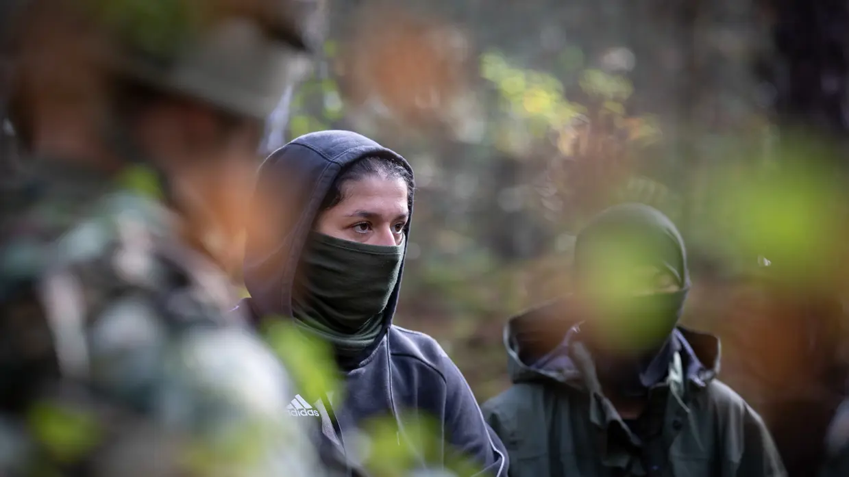 Drie gewapende militairen in gesprek met drie personen in donkere burgerkleding. Een vrouw met een donkere trui en een bedekt gezicht. Militairen in gevecht met de donker geklede partizanen. Twee militairen houden een persoon in burgerkleding vast terwijl diegene met zijn buik op de grond ligt.