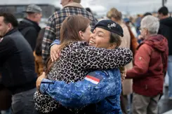 Twee vrouwen omhelzen elkaar op de kade van Den Helder