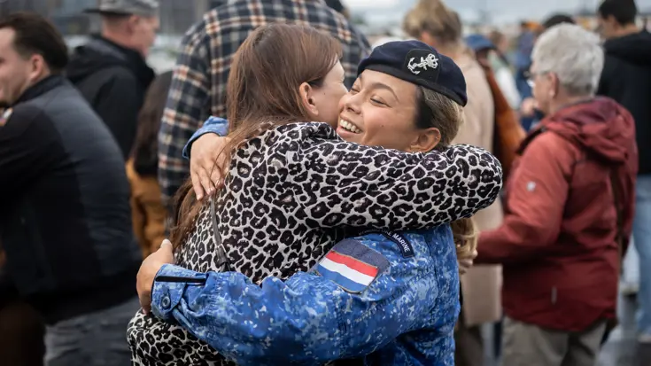 Twee omhelzende mensen, waarvan een een militair