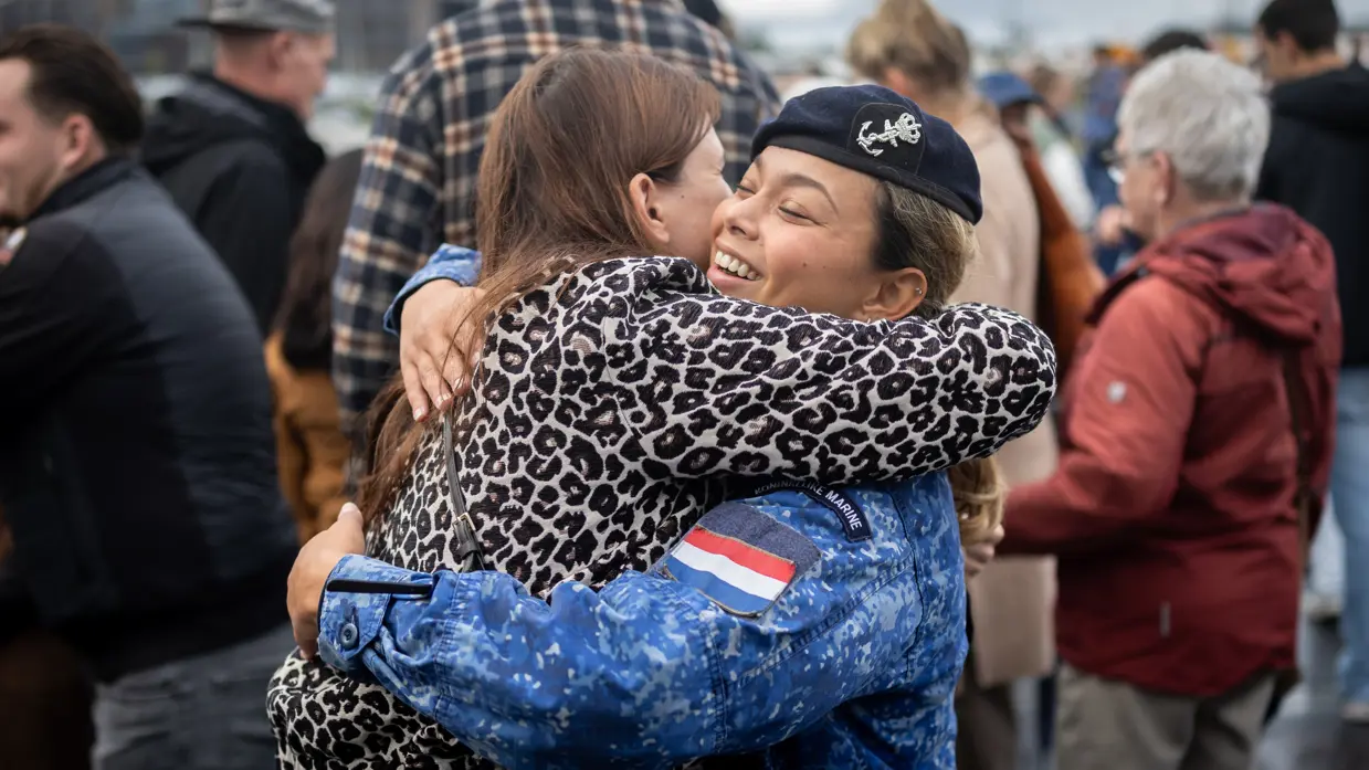 Twee omhelzende mensen, waarvan een een militair