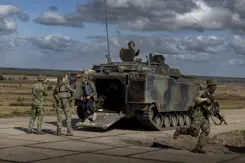 De premier komt een militair voertuig uitgelopen.