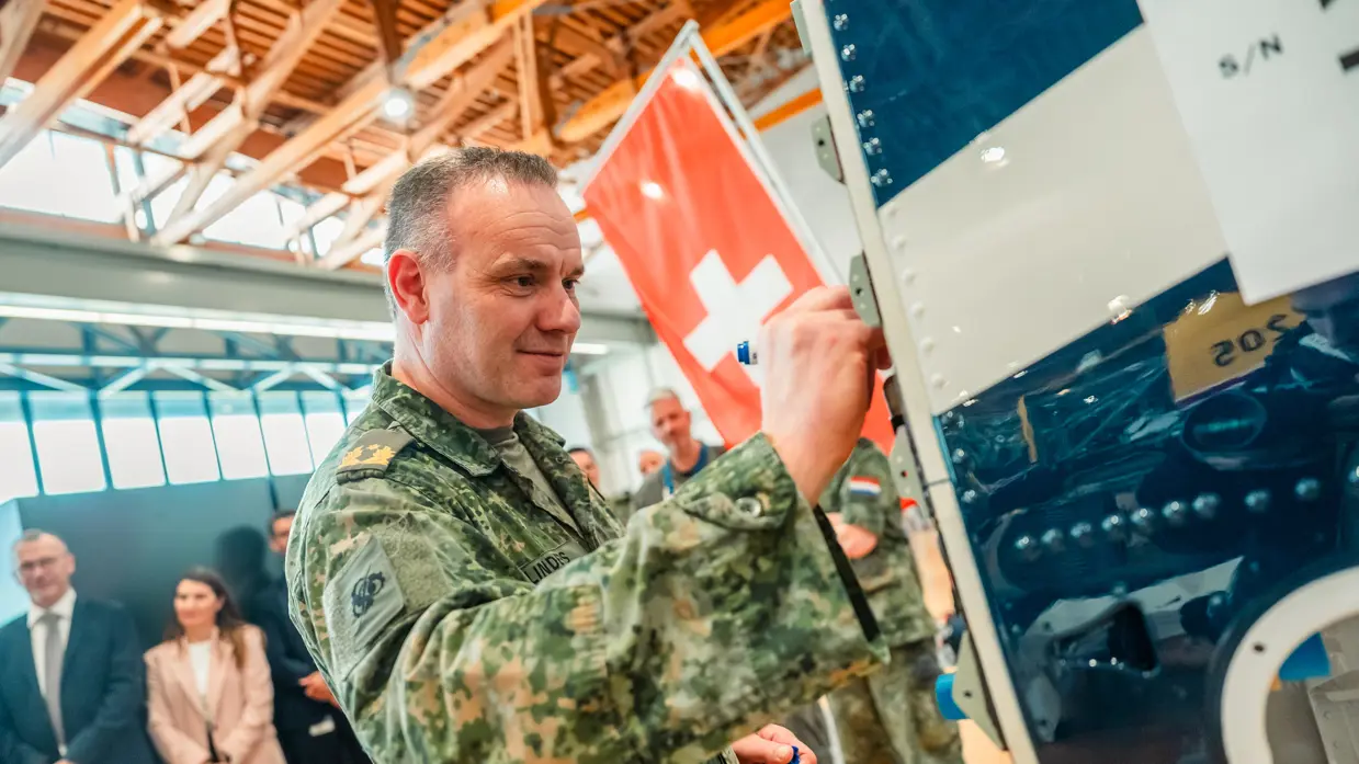 Een militair zet zijn handtekening op de romp van de eerste Nederlandse PC-7 MKX.