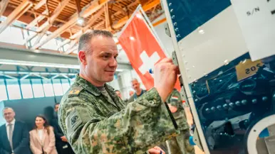 Een militair zet zijn handtekening op de romp van de eerste Nederlandse PC-7 MKX.