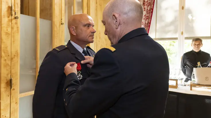 Militair krijgt een onderscheiding omgehangen.
