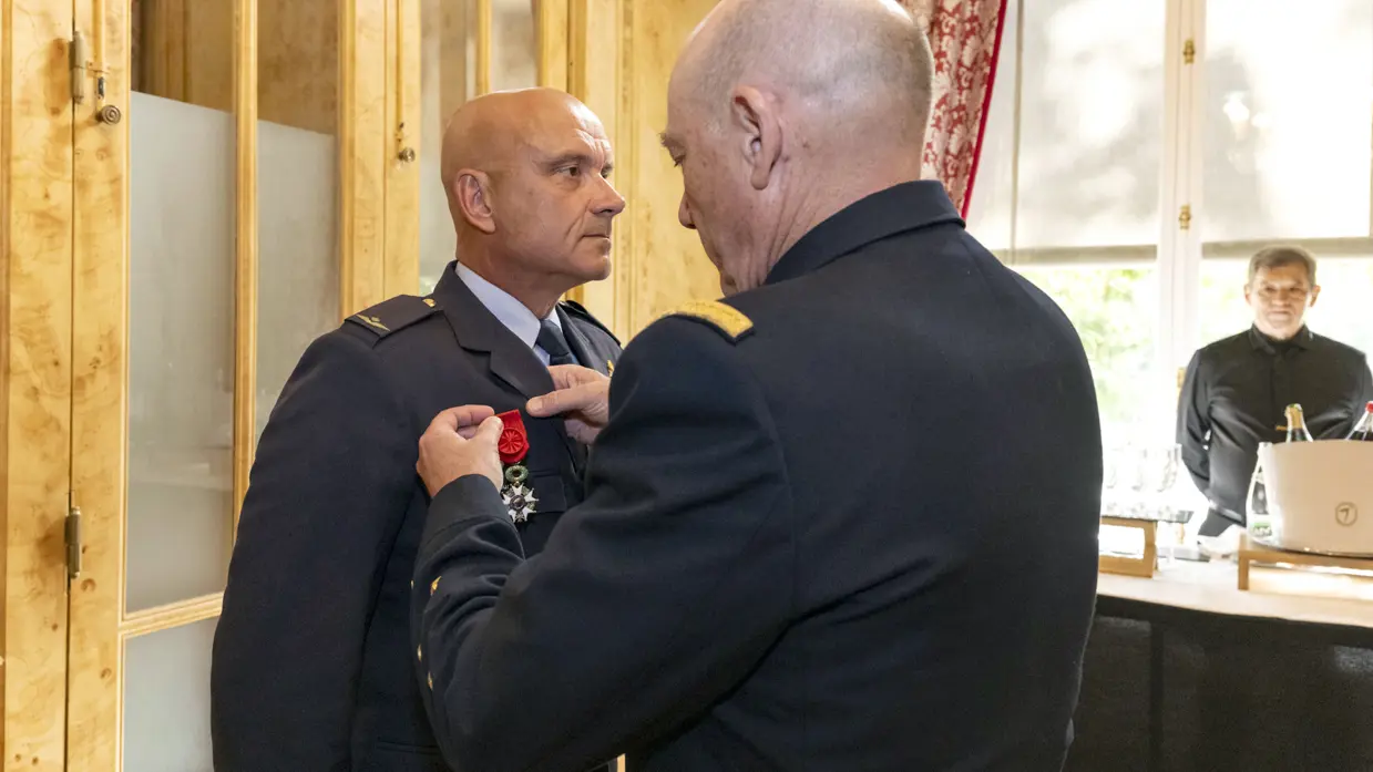 Een militair spelt een medaille op de borst van Steur.