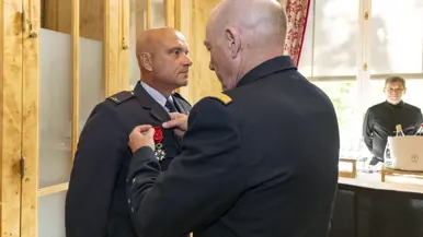 Een militair spelt een medaille op de borst van Steur.