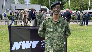 Een militair staat op een grasveld. 
