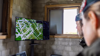 Syl en Lucas kijken naar een scherm, handen op het bedieningsbakje en handen op de laptop