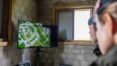 Syl en Lucas kijken naar een scherm, handen op het bedieningsbakje en handen op de laptop