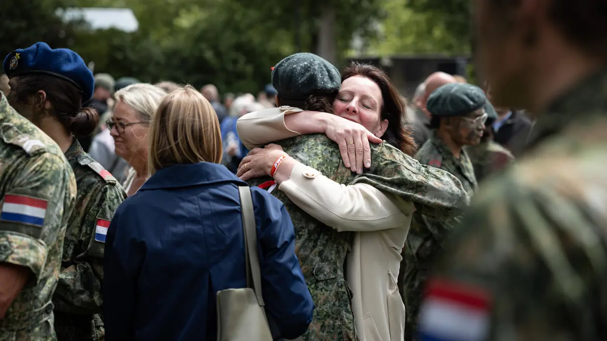 Militairen omhelzen hun familieleden.