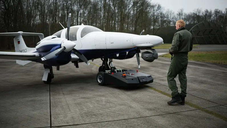 Diamond DA62 MPP-patrouillevliegtuig wordt met een grondvoertuig uit de hangaar gehaald. 