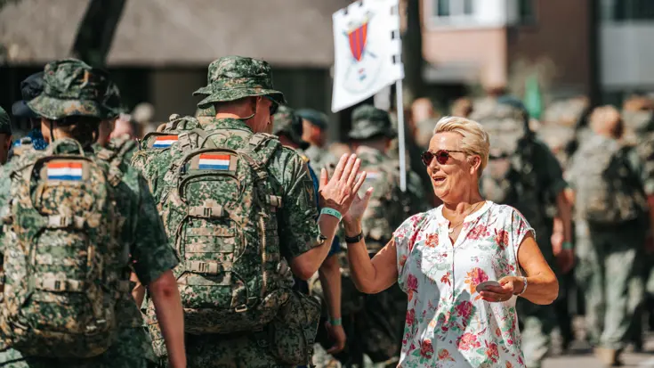 Een vrouw krijgt een highfive van een militair.