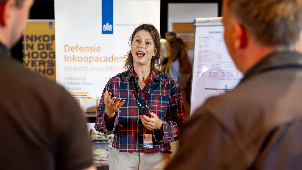 inkoopster spreekt met belangstellenden op marktplein van inkoopdag