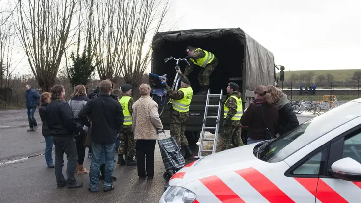 Reservisten werken samen met de politie bij de evacuatie van bewoners.