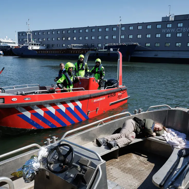 Vaartuig met een lotusslachtoffer met op de achtergrond een vaartuig van de Marechaussee.