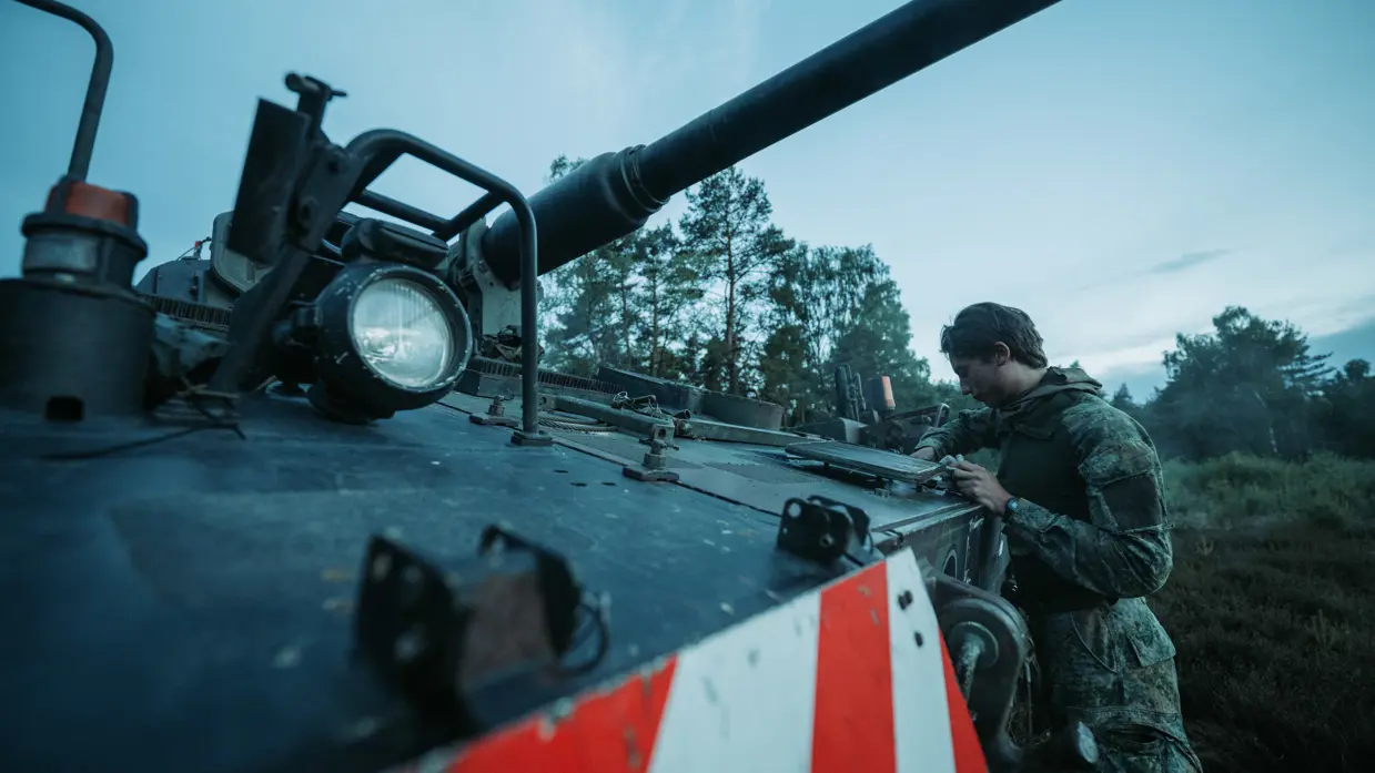 Een militair sleutelt aan een pantservoertuig.