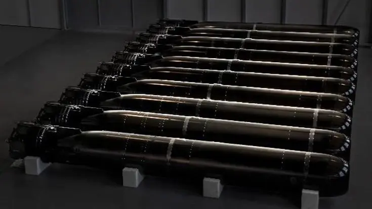 Een rijtje torpedo’s liggend in een bak.