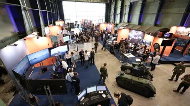 De zaal vanaf bovenaf gezien met daarin verschillende stands.