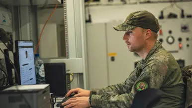 Een militair maakt gebruik van een computer.