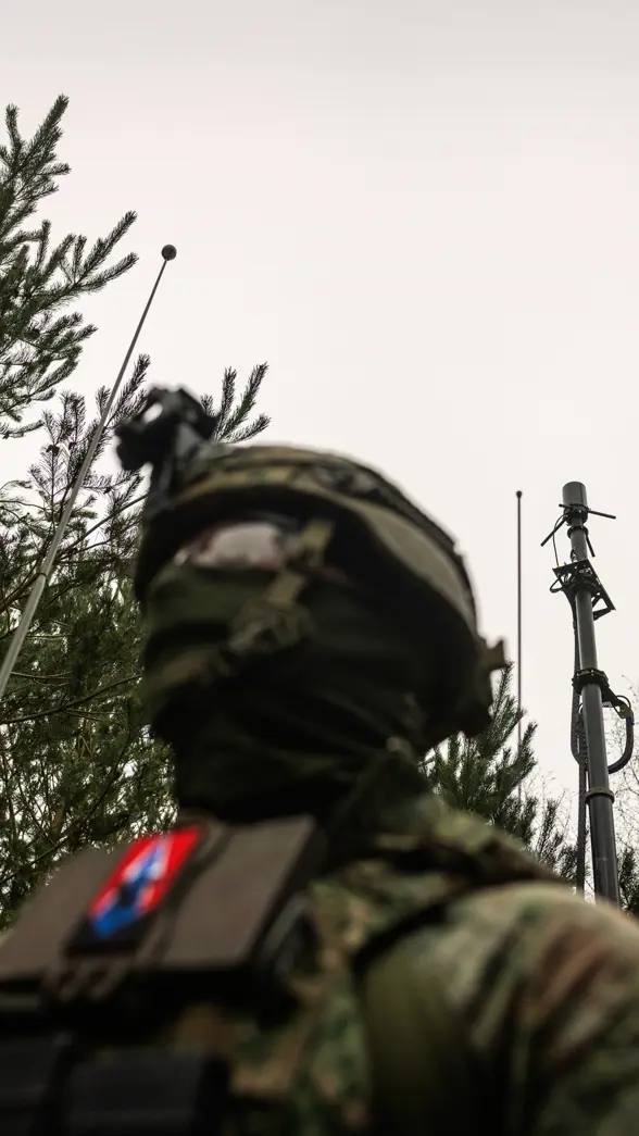 Een militair in het bos die een stabiel netwerk opzet.