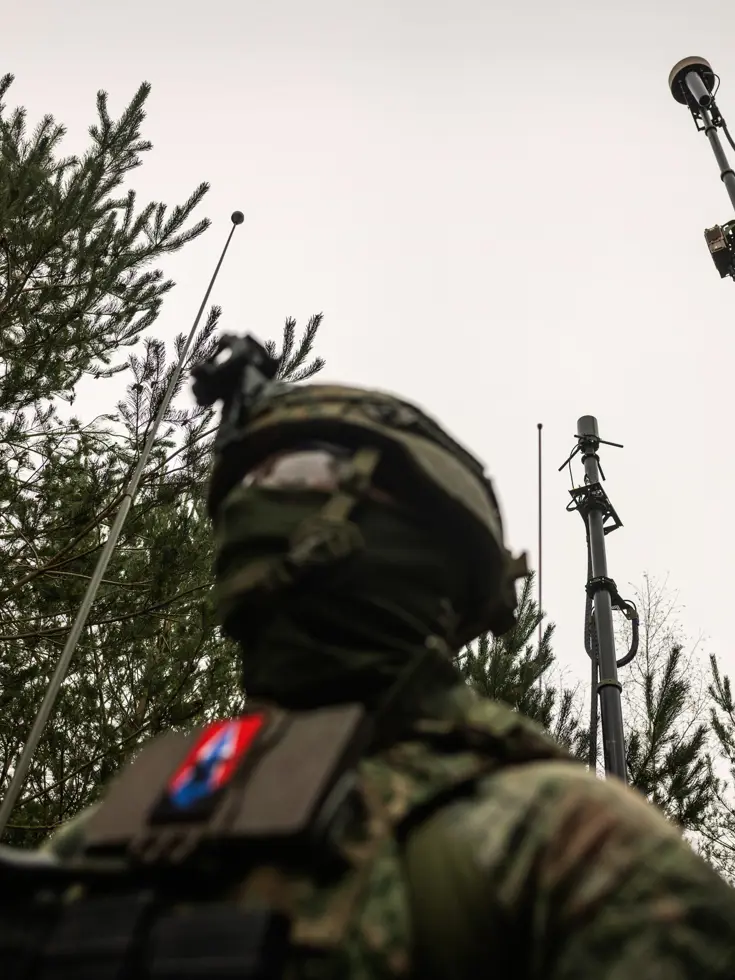 Een militair in het bos die een stabiel netwerk opzet.