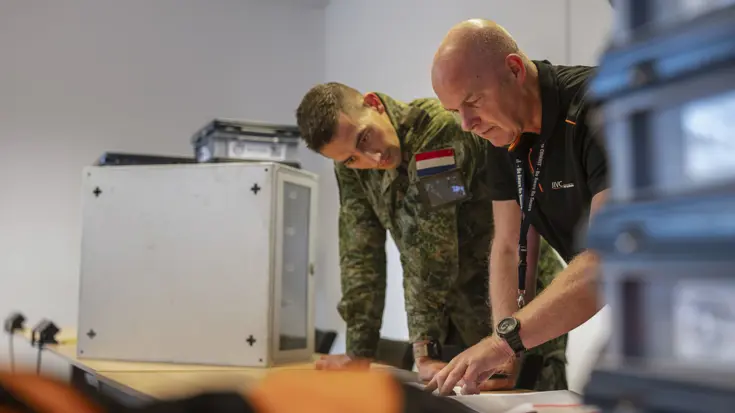 Projectleider Arno bekijkt samen met een militair de plannen voor de ICT-opbouw tijdens Falcon Leap.