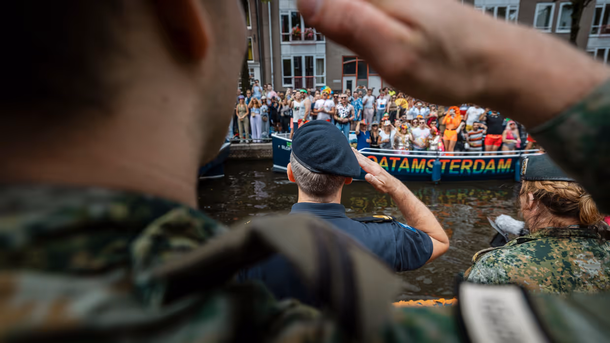 Militairen brengen de eregroet aan het publiek op de kant. 