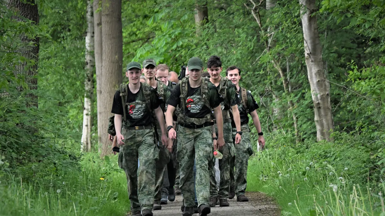 De militairen lopen door een bosgebied.