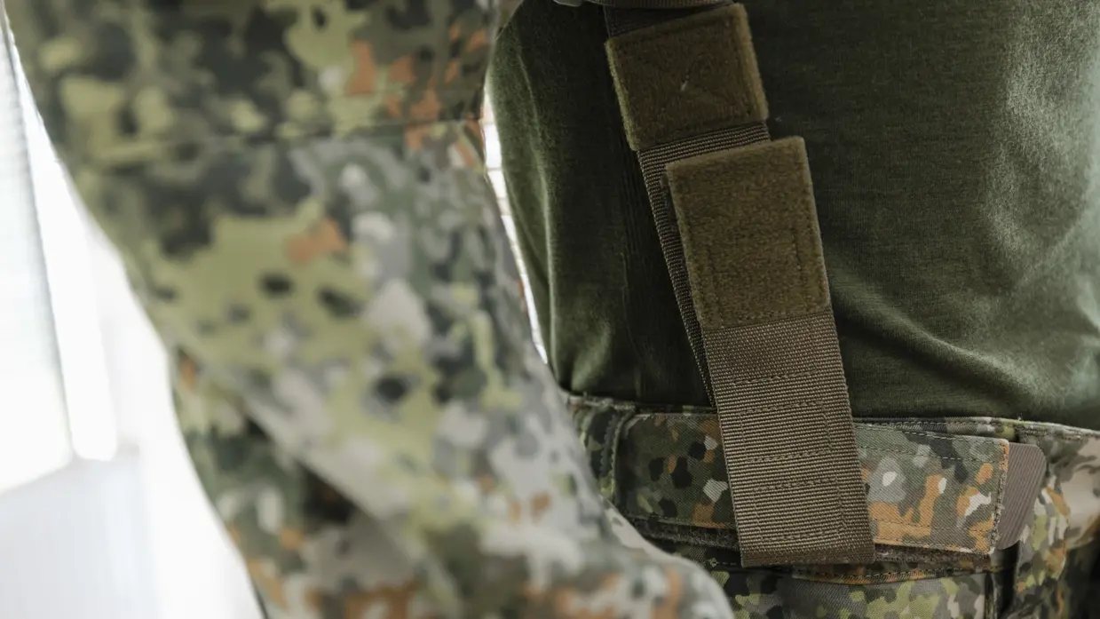 Bretels met klittenband houdt de broek van een militair omhoog.