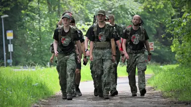 De militairen lopen door een bosgebied.
