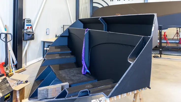 De neus van een 3D-geprinte boot met daarachter de romp van het vaartuig.