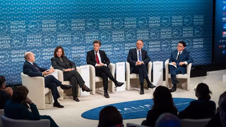 Minister Brekelmans zit in een paneldiscussie met 4 anderen. Op de blauwe achtergrond staat talloze keren: Halifax.